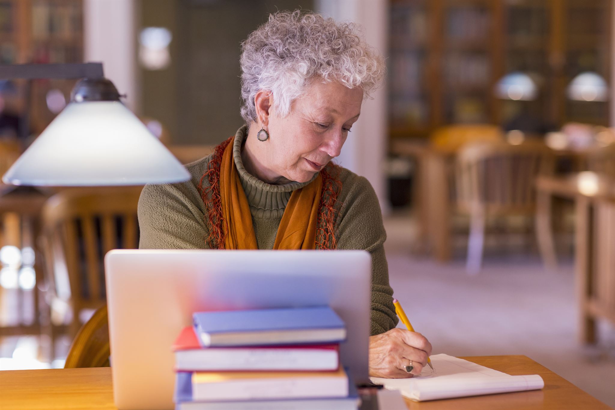 Senior-adult-working-at-desk-in-library